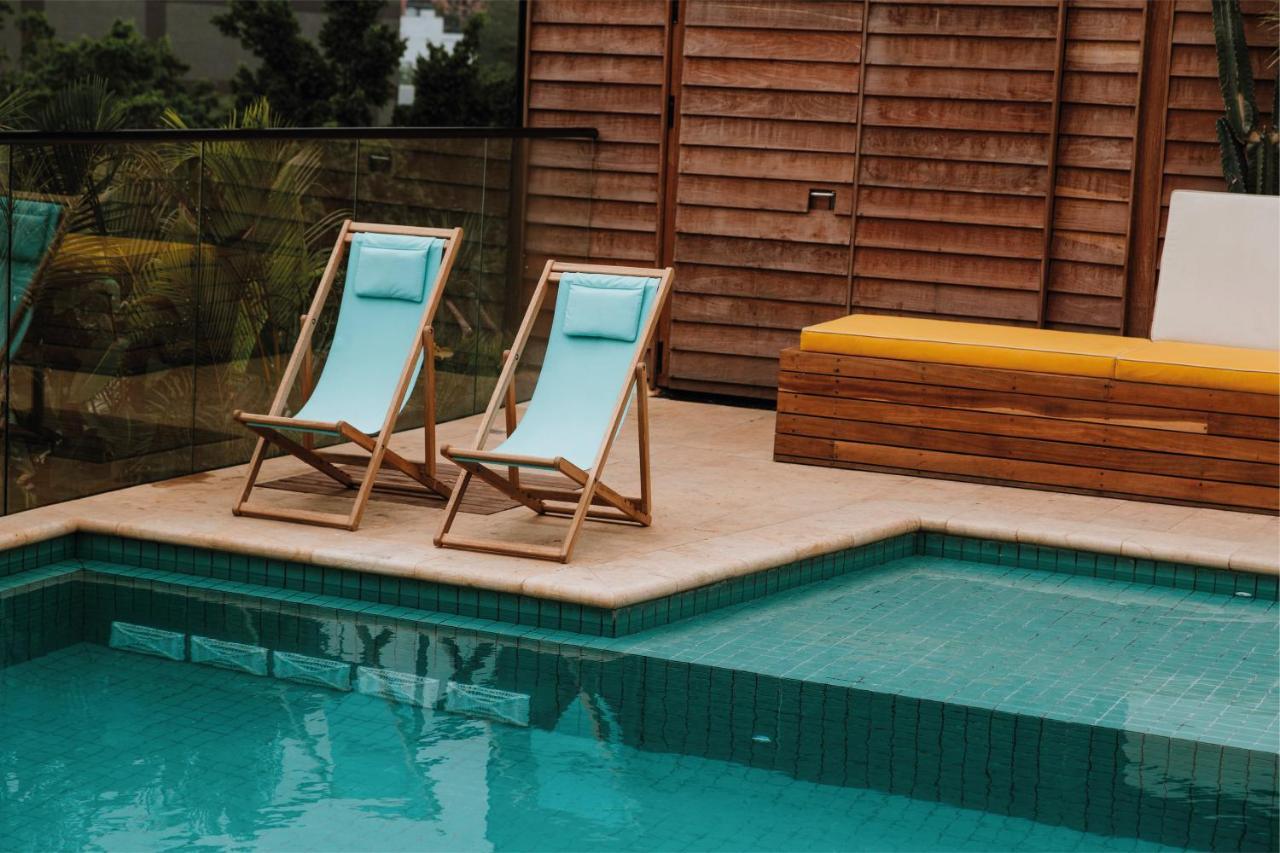 The Click Clack Hotel Medellín Esterno foto A pair of deck chairs by a pool